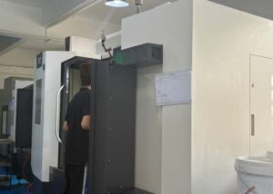 Technician operating multiple CNC machines in a precision workshop — showing real application of CNC machine in manufacturing