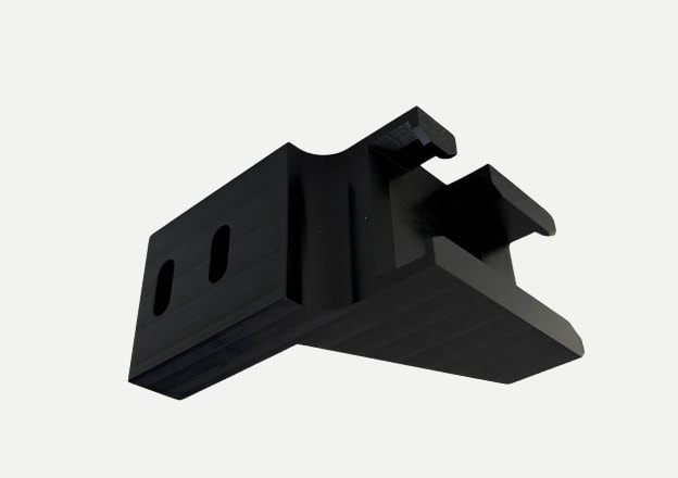 CNC machined black plastic block with precision slots and cutouts