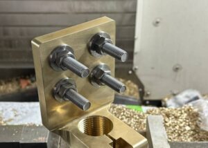 Custom brass CNC machined fixture with threaded holes and steel bolts