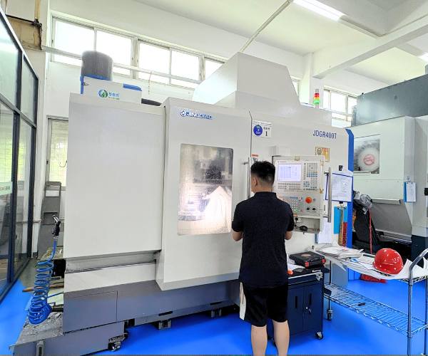 Operator working on a 5-axis CNC milling machine in TiRapid workshop