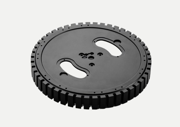 CNC machined black circular gear plate with cutouts and teeth design
