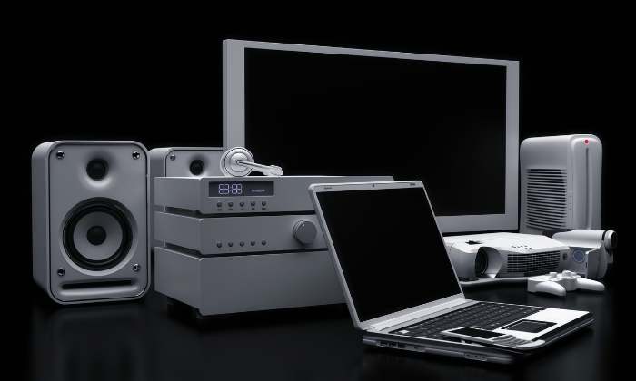 Collection of electronic devices including laptop, speakers, and monitor