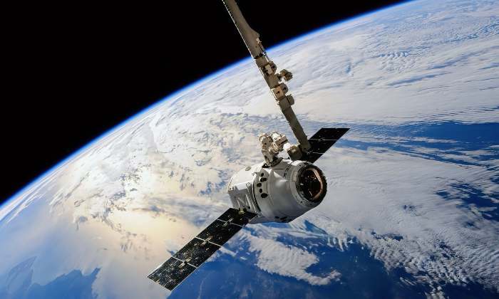 Satellite orbiting above Earth with solar panels