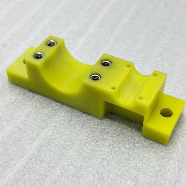 Rapid prototype plastic Garolite part with embedded metal inserts for enhanced durability, produced by TiRapid’s precision machining service.