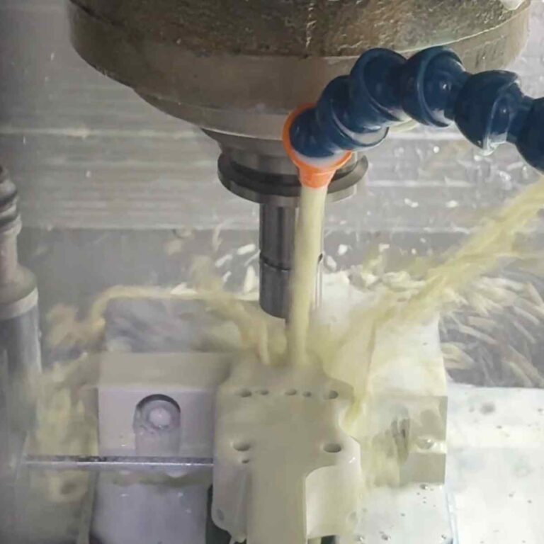 CNC machine cutting precision prototype components under coolant flow