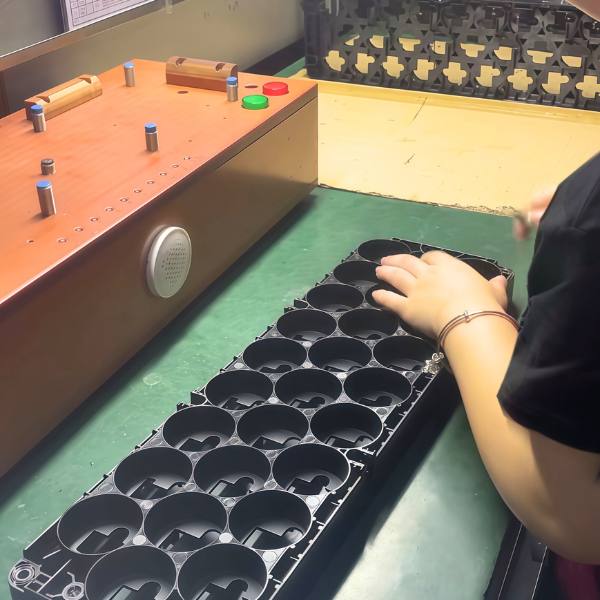Insert moulding process – worker assembling plastic insert moulded parts on production line, ensuring precision and quality