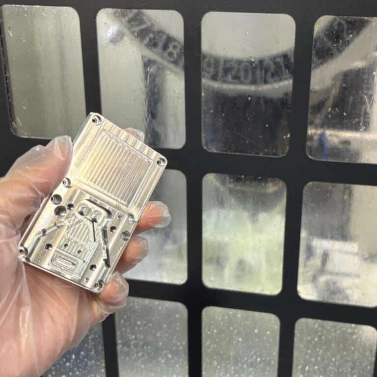 Precision aluminum CNC milled automation part shown in front of machining center, stiffness vs strength comparison