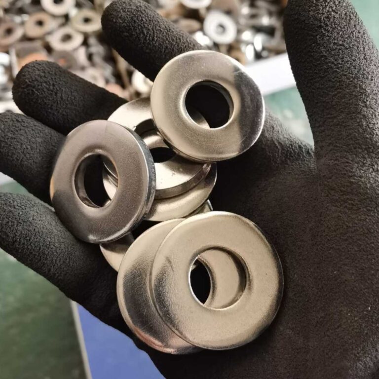 Operator holding a CNC-machined washer for visual inspection and quality check