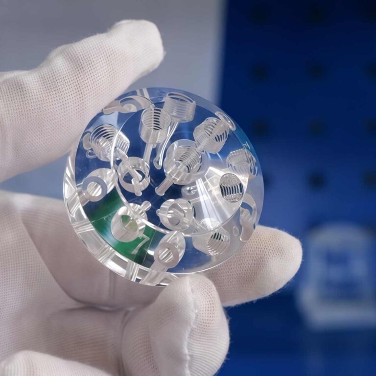 Hand holding a clear acrylic part, highlighting the transparency, smooth edges, and lightweight properties of acrylic for product design