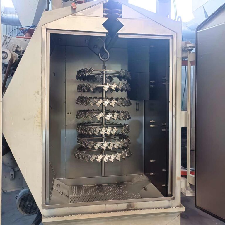 Stainless steel structural parts suspended inside a hanger-type shot blasting machine for surface treatment