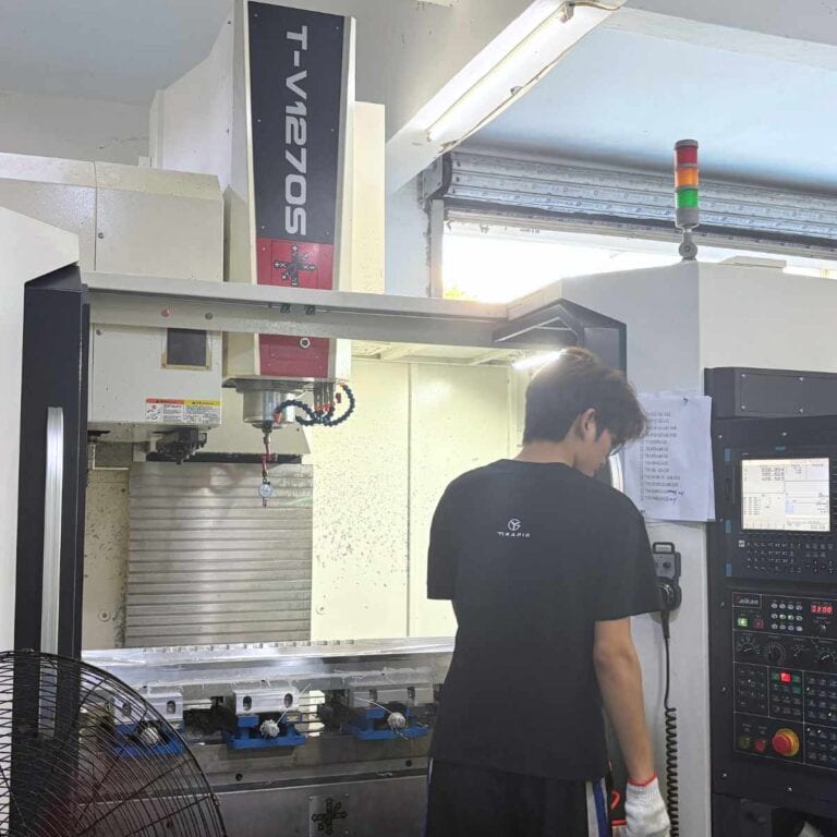 CNC milling operation during the prototype testing stage with an engineer verifying machining accuracy