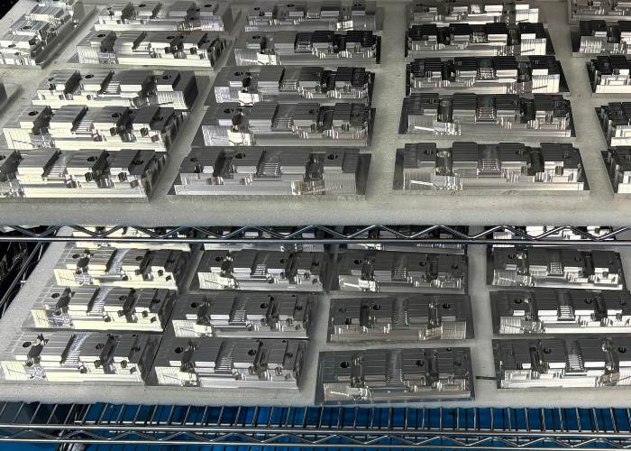Batch of precision steel prototype parts organized on shelf for stiffness vs strength engineering study