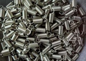 Bulk metal coil springs packed in a transparent bag, representing mass production for various types of springs and applications