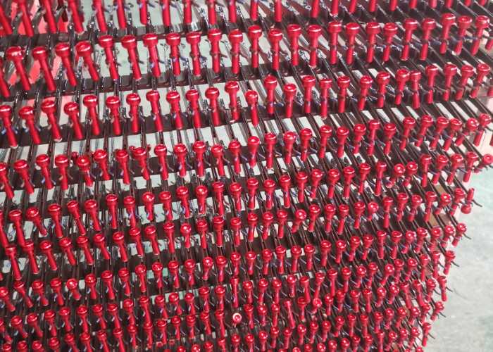 Red anodized aluminum prototype parts displayed on a shelf, illustrating uniform color and surface quality