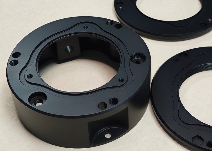 Precision CNC machined black anodized aluminum alloy camera accessory component with matte finish, corrosion resistance, and high dimensional accuracy.