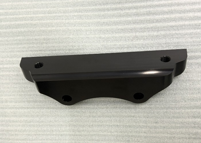 Precision CNC machined black anodized aluminum part with smooth surface finish, corrosion resistance, and accurate threaded features.
