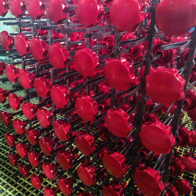 Red anodized aluminum part during CNC turning, showing the machining process for understanding what is anodized aluminum