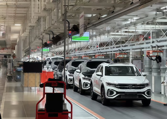 Worker assembling automotive parts on an automated production line