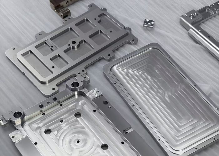 Precision metal prototype parts manufactured by CNC machining, showing complex cavities and tight tolerances