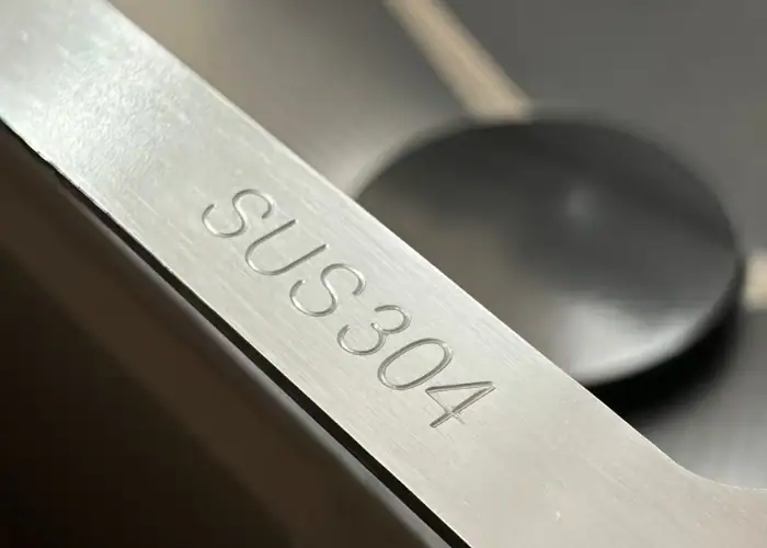 Close-up view of SUS304 stainless steel marking on a stainless steel component