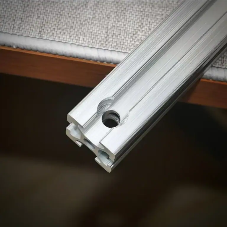 Close-up image of an aluminum profile with countersink holes showing the machining detail