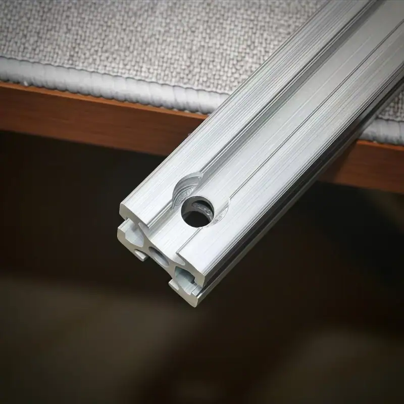 Close-up image of an aluminum profile with countersink holes showing the machining detail