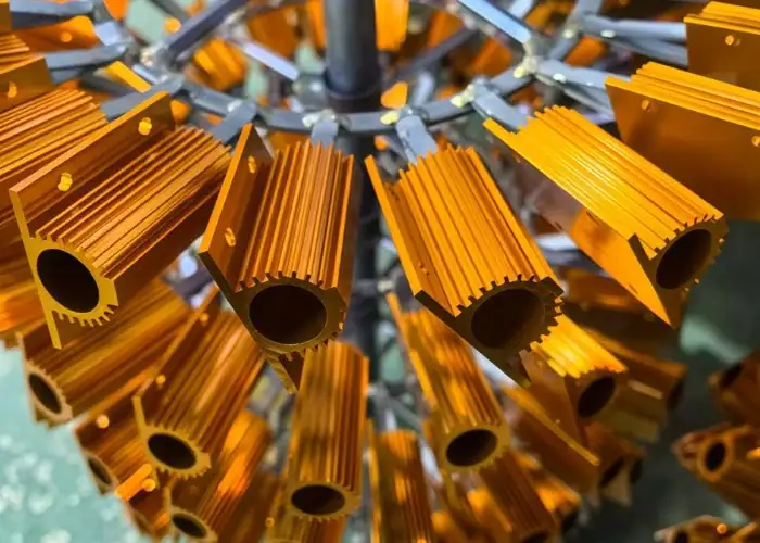 Gold anodized aluminum heat sink profiles arranged on an anodizing rack