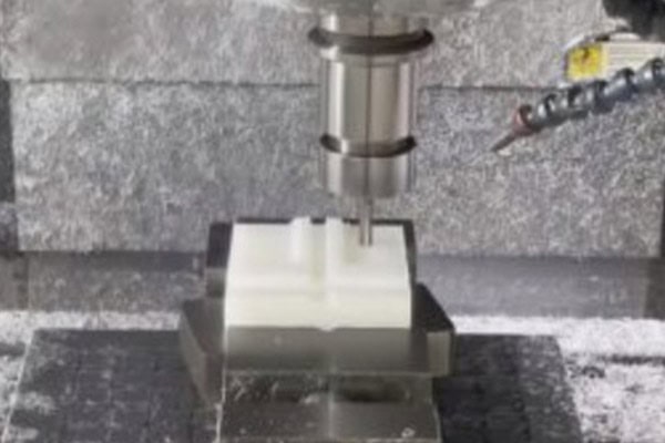 Image of a machine tool spindle cutting a white plastic workpiece.
