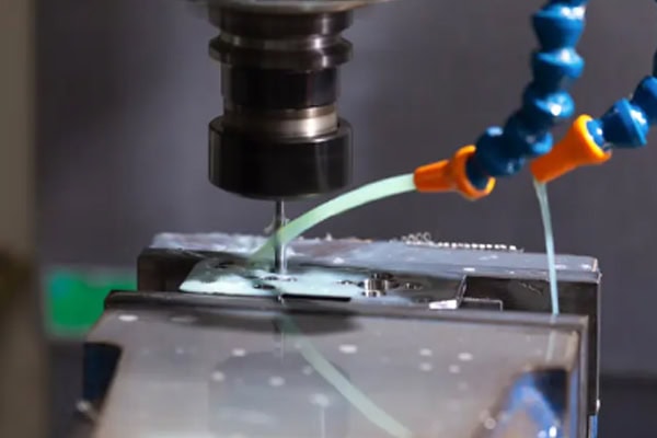 Images of wet metal cutting processes in CNC machining centers.
