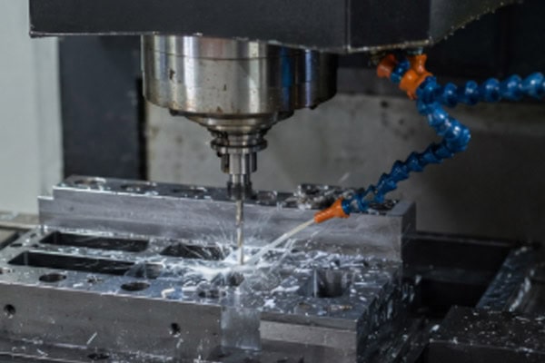 The spindle is holding the drill bit and is drilling and cutting aluminum parts.