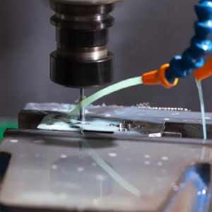 The spindle performs precision milling on the steel workpiece.