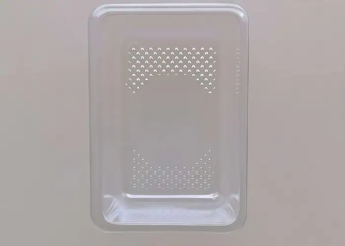 Transparent PET plastic thermoformed tray with ventilation holes, produced for packaging and molded plastic product applications.