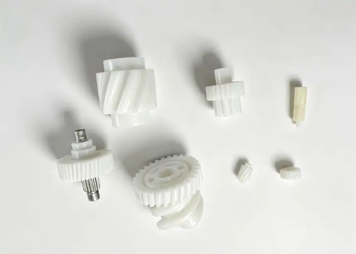 Injection molded plastic gears and shafts for mechanical assemblies