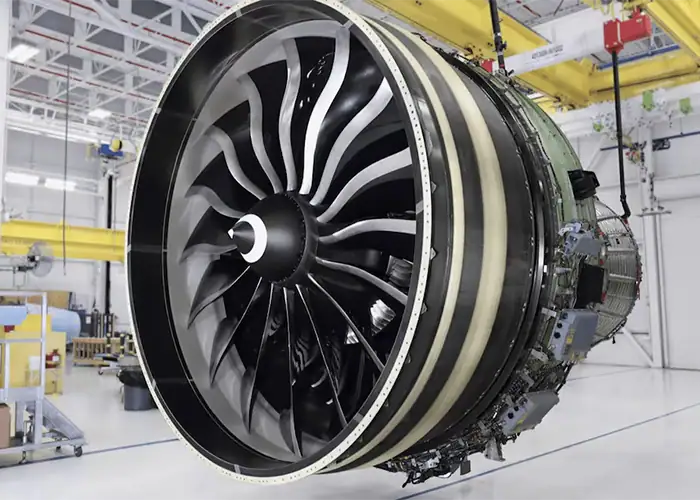 Large aero engine suspended in an assembly hangar, with the fan blades and fan case in view