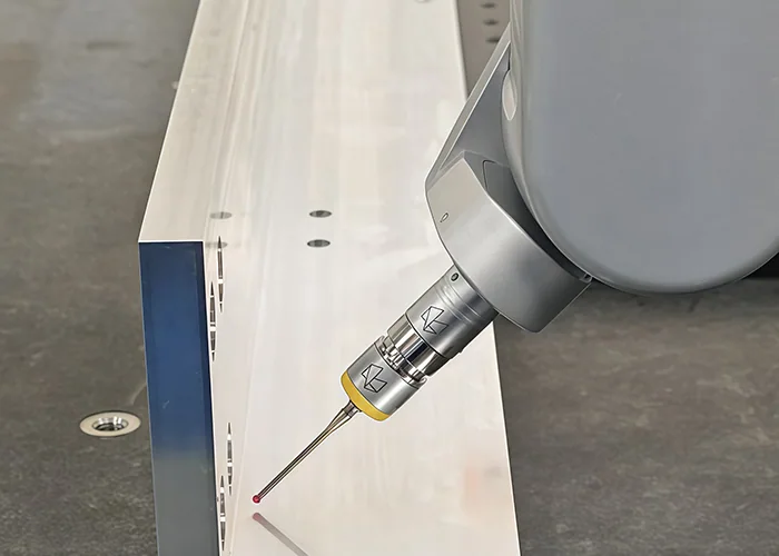 Angled CMM stylus positioned near the surface of a machined metal component