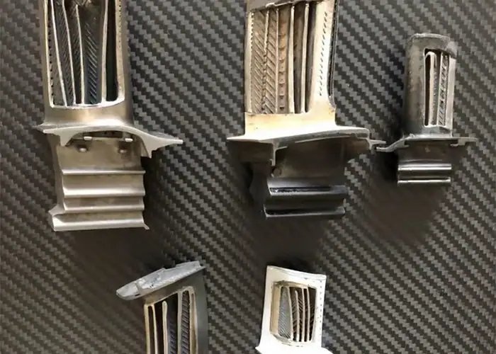 Cutaway turbine blade samples showing internal cooling passages and blade roots